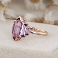 a pink tourmaline ring sitting on top of a white cloth