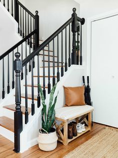 an entryway with a bench, plant and shoes on the floor