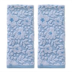 two blue hand towels with white flowers on the front and back of each towel are shown