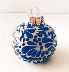 a blue and white ornament on a white table with a red stripe around the edge