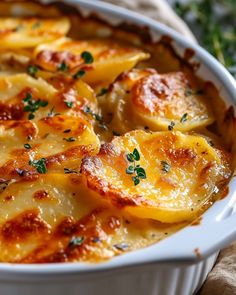 a casserole dish with potatoes and parsley in it on a tablecloth