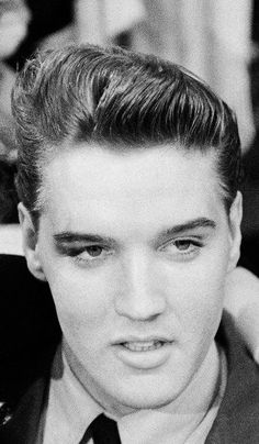 black and white photograph of a young man wearing a suit with his arm around the neck