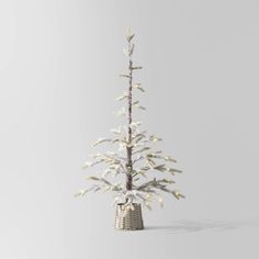 a small white christmas tree in a wicker basket