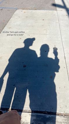 the shadow of two people standing next to each other on a sidewalk with a sign that says, it's the day get coffee and don't drink