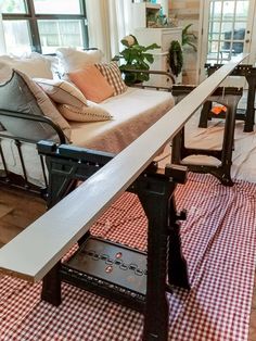 a living room filled with furniture next to a window covered in pillows and blankets on top of a checkered table cloth