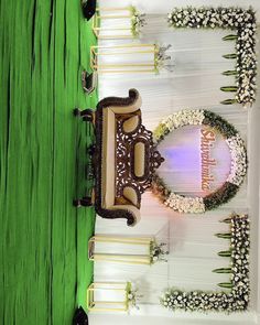 an elaborately decorated table with flowers and greenery on the top is surrounded by white chairs