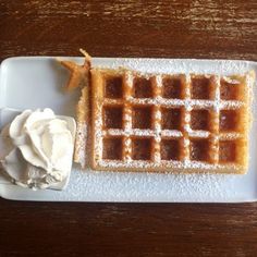 a waffle on a plate with whipped cream