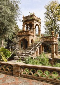 an old brick building with steps leading up to it and trees in the back ground