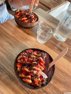 two bowls of food on a wooden table