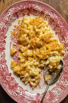 macaroni and cheese is served on a red and white plate with a spoon