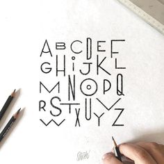 someone is drawing letters with pencils on paper