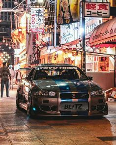 a car parked on the side of a street at night