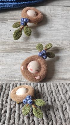 two small stuffed animals sitting next to each other on a wooden surface with leaves and flowers