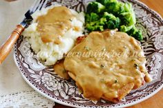 a plate with gravy, mashed potatoes and broccoli on it