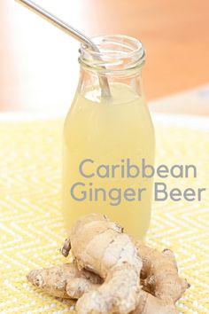 a glass jar filled with liquid next to some ginger root on top of a table