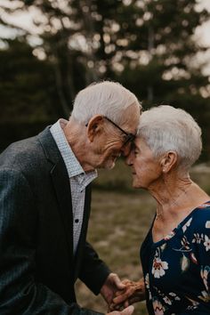 an older couple holding hands and smiling at each other