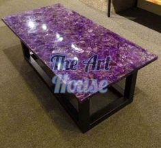 a purple table with the words the art house on it in front of a couch