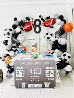 a sports themed birthday party with balloons and footballs on the wall, including a scoreboard