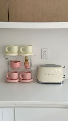 a toaster and cups are sitting on the counter