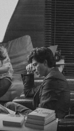 black and white photograph of two people sitting at a table with books in front of them