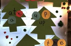 a bulletin board with cut out christmas trees and words on the bottom, below which reads see at u up me the tree