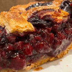 a close up of a pie on a plate with crumbs and blueberries