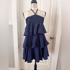 Navy Blue Tiered Halter Mini Sundress Smocked Back Three Tier Flowing Design Very Slimming And Flattering Adjustable Tie At Neck Fully Lined Side Zipper Closure Lightweight Satin Feel Material Brand New With Tags By Boutique Brand Fashion Ying Women’s Size Small 4-6 Pit To Pit 14-17” Total Length Pit To Bottom Hem 25” Bin W Tags- Gypsy, Boho, Chic, Wedding, Sunday, Weekend, Party, Fairy, Shower, Church, Beach, Holiday, Pin Up, Pinup, Sexy, Spring Break, Summer, Betty Paige, Romantic, Cocktail Su Tiered Cotton Mini Dress With Smocked Back, Blue Flowy Tiered Dress With Ruffles, Chic Blue Tiered Dress With Ruffle Hem, Blue Mini Length Tiered Dress For Spring, Blue Tiered Ruffle Dress For Vacation, Blue Tiered Mini Dress With Smocked Back, Blue Ruffled Tiered Dress For Vacation, Blue Tiered Smocked Dress With Ruffles, Blue Tiered Dress With Ruffle Hem For Beach