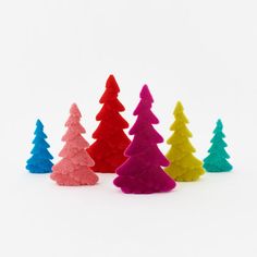 small plastic christmas trees in different colors on a white background