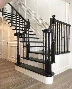 a black and white stair case next to a wooden floor