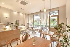 the interior of a restaurant with tables, chairs and potted plants on the counter