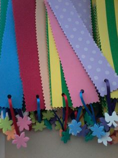 colorful paper flowers and ribbons are hanging on the wall with polka dot trimmings