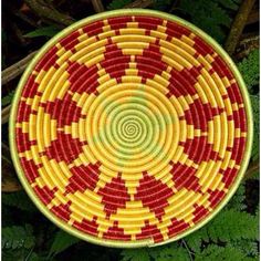 a red and yellow basket sitting on top of green leaves