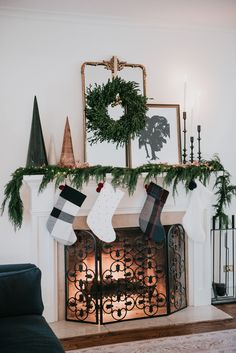 a fireplace with stockings hanging from it's mantle and christmas decorations on the mantel