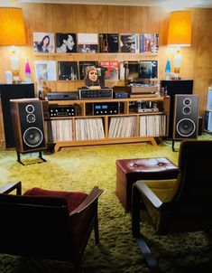 a room filled with lots of furniture and speakers on top of wooden shelves next to each other