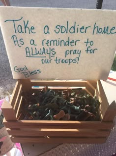 a wooden box filled with lots of green leaves and some writing on the sign that says, take a soldier home as a reminder to always pray for our troops