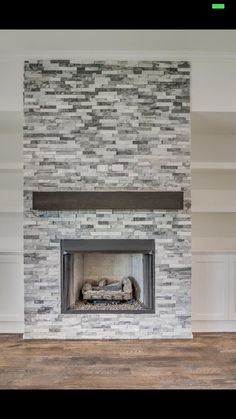 an empty room with a fireplace and shelves