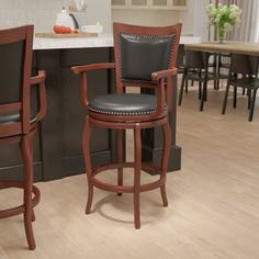 two black leather barstools in a kitchen with wood flooring and counter tops