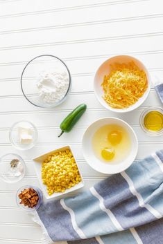 the ingredients to make this dish are laid out on a striped towel, including eggs, corn, and seasonings