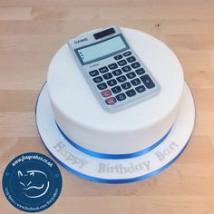 a birthday cake with a calculator on it and a happy birthday sticker