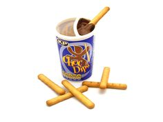 an ice cream cup filled with chocolate and cinnamon sticks next to some small crackers