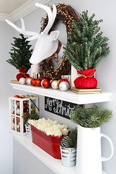 a shelf with christmas decorations and deer head on it's back, along with other holiday items