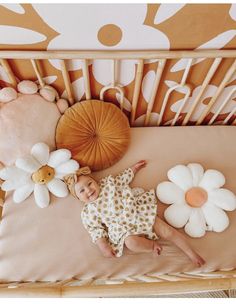 a baby laying in a crib next to flowers