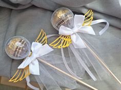 two lollipops with bows on them sitting on top of a cloth bag