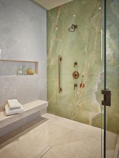 a bathroom with a glass shower door and marble counter top