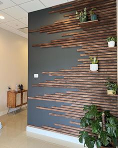 the wall is made out of wood strips and has potted plants on each side