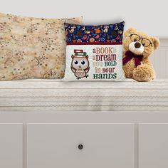 a teddy bear sitting on top of a white bed next to two pillows and a pillow case