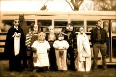 a group of people standing in front of a bus with halloween masks on their faces