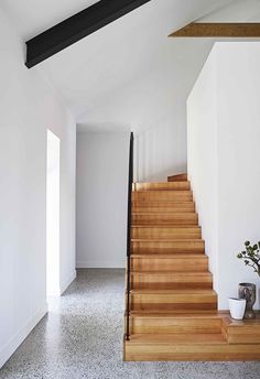 the stairs are made of wood and have black railings on one side, while the other