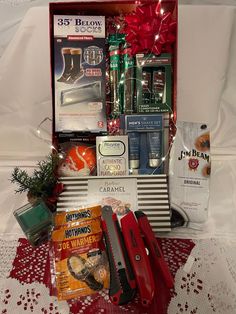 an assortment of items displayed in a box on a lace tablecloth with red bows