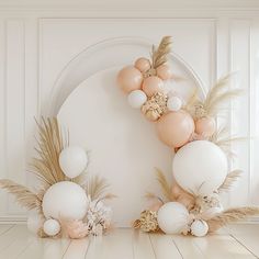 an image of balloons and flowers on the floor in front of a white wall with gold accents